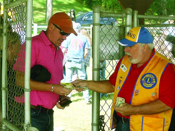 Lion Club member Richard Biehl takes money at the festival’s busy south entrance, where shuttle buses parked to let passengers off.