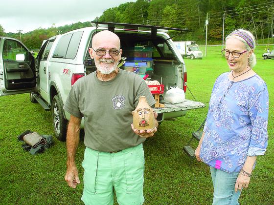 Apple Festival vendor Ken Barker, The Clogging Potter, shows one of his handmade face jugs alongside wife, Rita. The two traveled from Tallahassee, Fla., for their first time as Apple Festival vendors. 