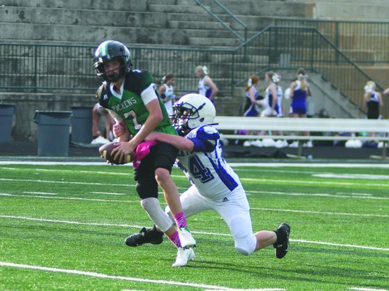 Clear Creek Middle School eighth grader Blake Grizzle wraps up Pickens’ quarterback to force an intentional grounding in the semifinals of the playoffs last Thursday.