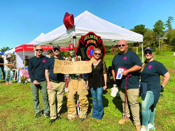 Above, from left, Chief Daniel Kauffman, Al Cash, mascot Mr. Bones, Stephanie Kauffman, Marshall Rhodes and Callie Rhodes celebrate retaining their chili championship.