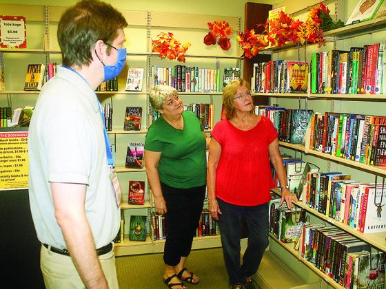 Friends of the Gilmer County Library Laura Huster, center, and Galen Forbes, right, look over what’s available at The Bookshelf with library manager Alex Thomerson. 