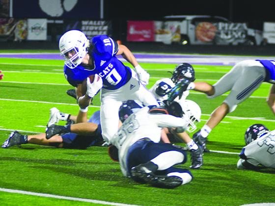 Gilmer High junior halfback Will Kiker makes his way through a mass of humanity last Friday against West Hall. Kiker rushed for 102 yards and scored a 70-yard touchdown in the third quarter of the Bobcats’ 26-21 victory.