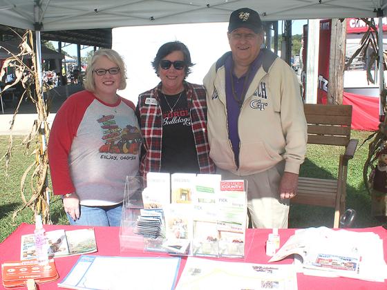 Paige Hutto, left, is shown at the Apple Festival’s information tent with Gilmer Chamber Membership Manager Ellen Grant, center, and chamber board member John Marshall. 