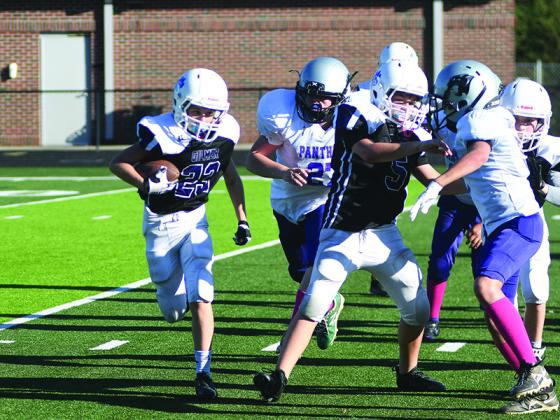Halfback Treven Brown (23) looks for some running room behind the block of Madden Hopkins (5) in the sixth-grade game.