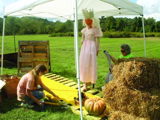 Weslee Upchurch, left, and Charlene Tittle, right, of Artful Ellijay, work on their Wizard of Oz-themed scarecrow display at Harrison Park.  