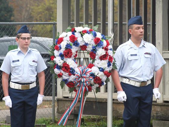 Civil Air Patrol 507th Composite Squadron cadets Luke Hardeman, left, and Joshua Carwell, right, place a wreath at the Lions Club flagpole as the service concludes.