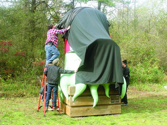 Atlanta set piece designers Russ Vick, Sam Carter and Chris Brown work on covering their 12-foot creation before its official unveiling last week.