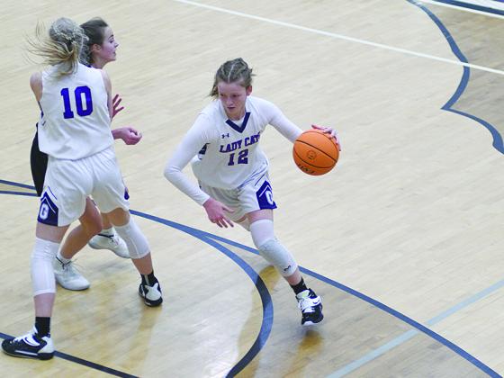 Gilmer High’s Brooke Wilson (12) makes her way around a screen set by teammate Lark Reece (10).