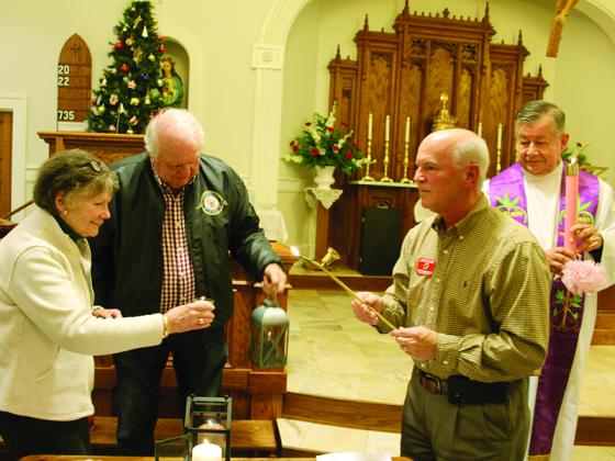 A couple of attendees at last Saturday’s Bethlehem Peace Light ceremony at Good Samaritan Catholic Church get their candles and lanterns lit in order to carry the flame to their homes and/or respective churches. From left are Ginger Hussian, Richard Byers, organizer Jack Planchard and Monsignor Jaime Barona, a retired priest from Gainesville. Planchard said the flame traveled around 6,500 miles to get from Bethlehem to Ellijay. 