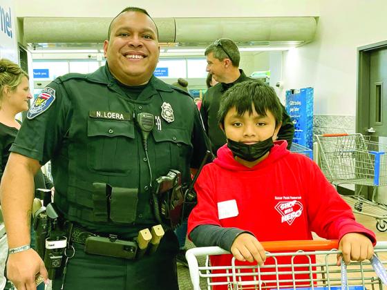 Officer Noel Loera, of the East Ellijay Police Department, left, accompanies his Shop With a Hero partner, Marbin Bautista, at the East Ellijay Walmart. 