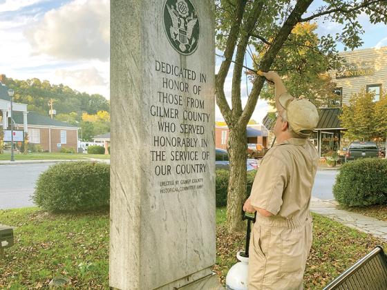 Michael Smith cleans the veterans monument on the Ellijay town square. 