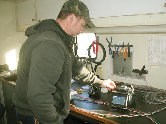 ETC fiberoptic technician Michael Reed splices a strand of the glass fiberoptic cable that provides broadband internet service to customers. 
