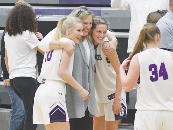 Gilmer seniors Lark Reece and Elly Callihan celebrate with head coach Susan Nunn following the Lady Cats’ 62-47 win versus North Hall last Tuesday. The game marked Nunn’s final regular season home game as the Lady Cats’ head coach.