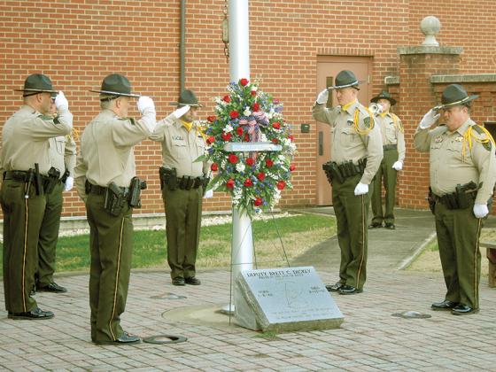 Above, Gilmer County Sheriff’s Office personnel stand at salute around a memorial dedicated to late Gilmer Deputy Brett Dickey during a service for the 26th anniversary of Dickey’s death in the line of duty. Pictured, clockwise from left:  Cpl. Al Greenway, Sgt. Randy Beavers, Aux. Dep. Josh Chancey, Lt. Gene Hefner, Dep. Ryan Scott, Aux. Dep. Bill Hall and Capt. Brian Crump. 