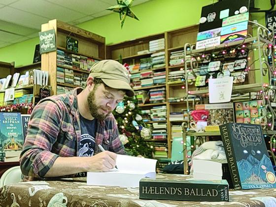 Above, Ian Conrey signs copies of his first book, Hælend’s Ballad, at Book Exchange in Marietta.