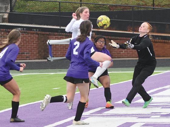 Gilmer goalkeeper Caitlin Henderson (right in black) moves in to snatch the ball during last Friday’s match against North Hall.