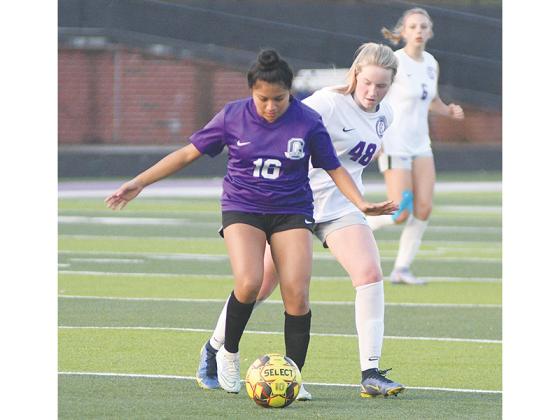 Gilmer High Lady Cat Yenifer Lopez shields the ball from a Cherokee Bluff midfielder before passing to the wing last Friday.