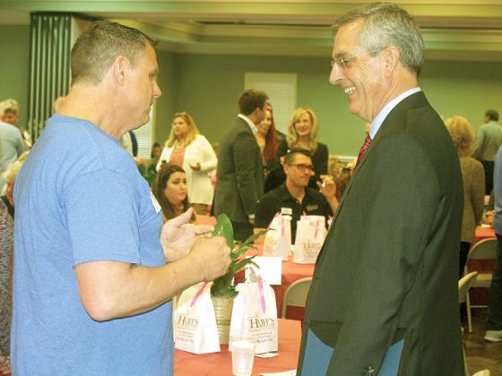 Georgia Secretary of State Brad Raffensperger, right, talks with Kerry McDearmid, of Mac and Son Plumbing, at a March 10 Gilmer Chamber luncheon. 