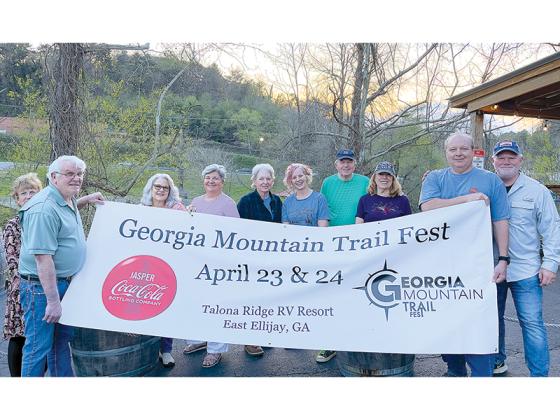 Representatives of the Georgia Mountain Trails Partnership and the Georgia Mountain Trail Fest put up a banner for the event. Pictured, from left: Penny Strickland, Tom Strickland, Brenda Miller, Karleen Ferguson, LuAnn Lackey, Kim Adamson, Roy Turner, Judy Turner, David Miller and Robert Ferguson.