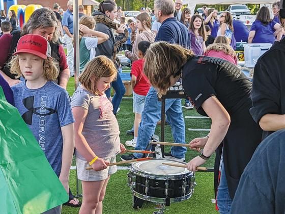 Second grader Sabrina Paschal receives a drumming lesson from GHS eleventh-grade band member Kiley Richard.