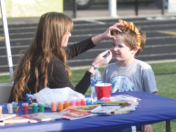 At Mikella Rutter’s FCCLA tent, GHS senior Jaylin Vick turns first grader Hezekiah Richards into a tiger.