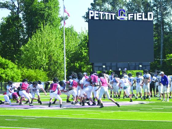 Gilmer High’s newly-installed video scoreboard towers over Pettit Field as the Bobcats engage in 11-versus-11 drills at Monday’s spring practice.