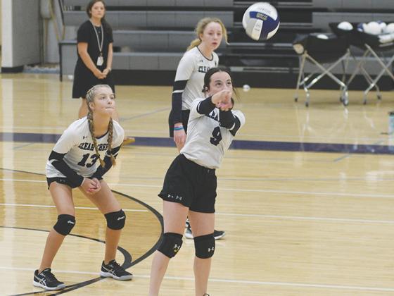 Lady Cat Alyssa Hughes (9) keeps a rally alive versus Dawson County last Tuesday as Alli Burton (13) gets in position.