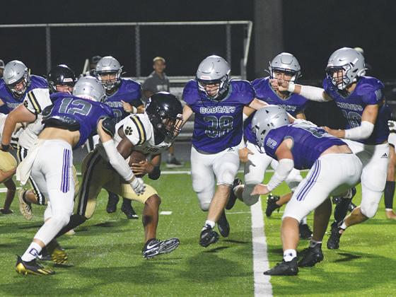 Gilmer Bobcat defenders Hayden Morrison (12), Dakota Nelson (38), Aspen Hataway, Will Kiker (10) and Kyle Cowart (15) swarm to make a tackle versus Commerce last Friday.