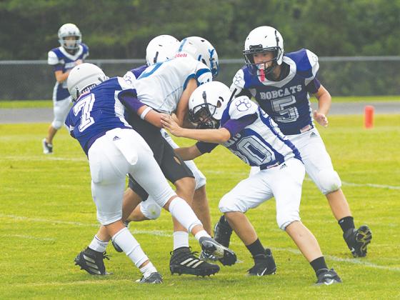 From left, Clear Creek’s A.J. Callihan (7), Jonathan Tanner (20) and Madden Hopkins (5) make a tackle for the Bobcats.