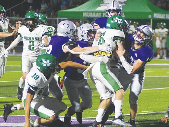 Gilmer High Bobcats Grant Ballew (2), Aspen Hataway (31) and Mason Smith (14) bring down Murray County’s Noah Densmore last Friday. 