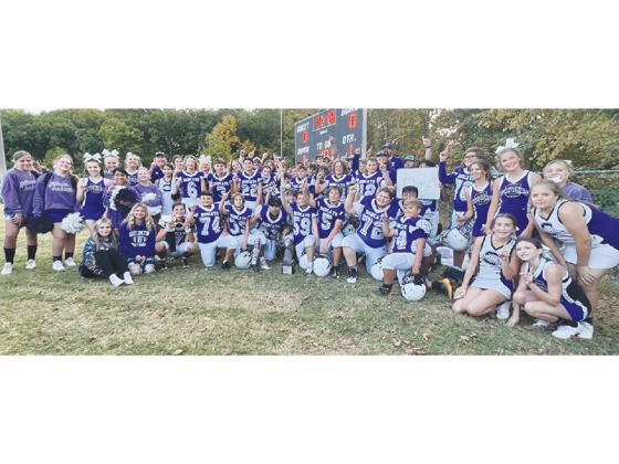 Clear Creek Middle School football players, coaches and cheerleaders gather around the seventh-grade Bobcats’ championship trophy following their 14-6 victory over Lumpkin County last Tuesday. 