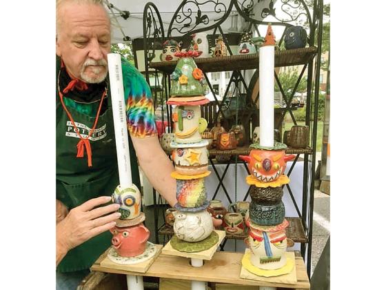 Potter Jack Meacham arranges some of his artwork at a past Dancing Goats Folkfest. 