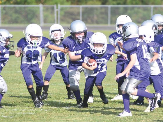 Gilmer second-grade running back Payden Thurman finds a hole in the line for a big gain.