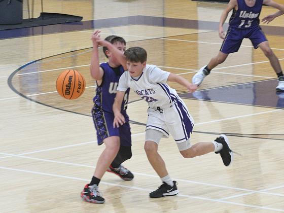 Above in white, Clear Creek’s Silas West swipes a steal for the seventh-grade Bobcats. 