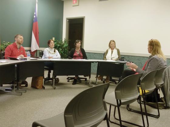 Ellijay Downtown Development Authority (DDA) members Reece Sanford, Sarah Burnette, Ellen Grant and Melinda Hadden listen as Nan Flickinger, right, describes her idea for a new apple-themed scavenger hunt for kids.  
