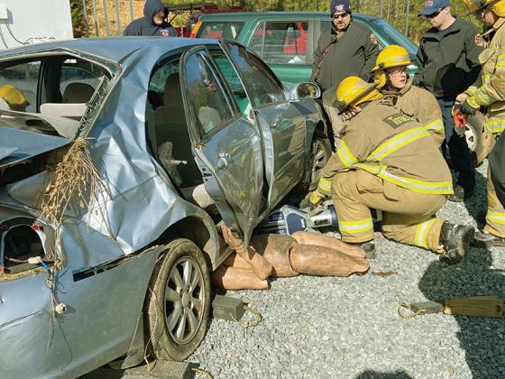 Gilmer Fire and Rescue Class 22-1 recruits Jake Knight and Jon Henderson use the jaws of life during a superdrill that put their firefighter training to the test. Also pictured, supervising, are instructors Lt. Will Sergent and Matt Bagley. (Gilmer Fire and Rescue photos)