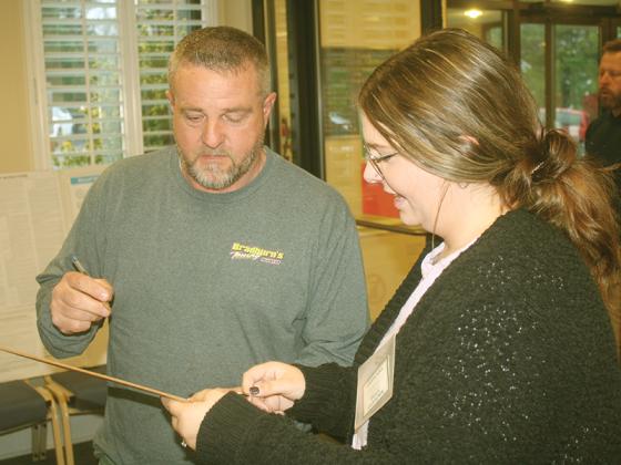 Poll worker Alexandra Chastain helps voter Michael Flowers get signed in at the East Ellijay City Hall polling place during the Georgia U.S. Senate runoff election Tuesday, Dec. 6. 