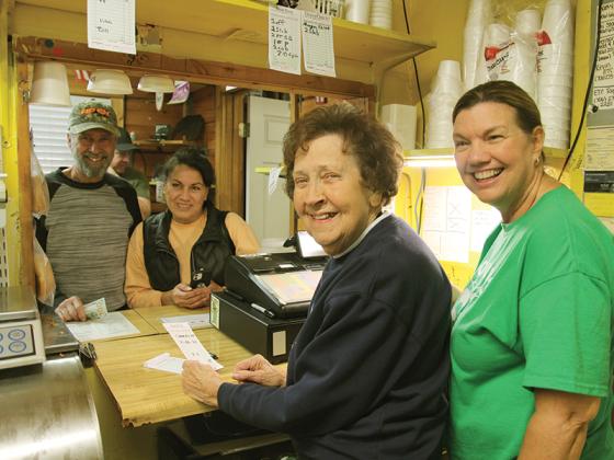 Edna and Melanie Poole ring up the last customers, Gary and Selean Newsome, at Poole’s Bar-B-Q during the East Ellijay restaurant’s last day of business Saturday, Nov. 26. Gary was also the first customer at Poole’s when the restaurant first opened. (Photo by George Winn)
