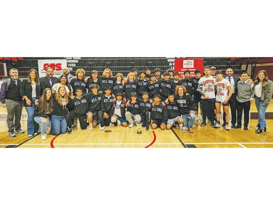 Gilmer High School wrestlers, coaches and managers gather around the Bobcats’ runner-up trophy from the Class 3A state duals. It marked Gilmer’s seventh consecutive second-place finish at the tournament.