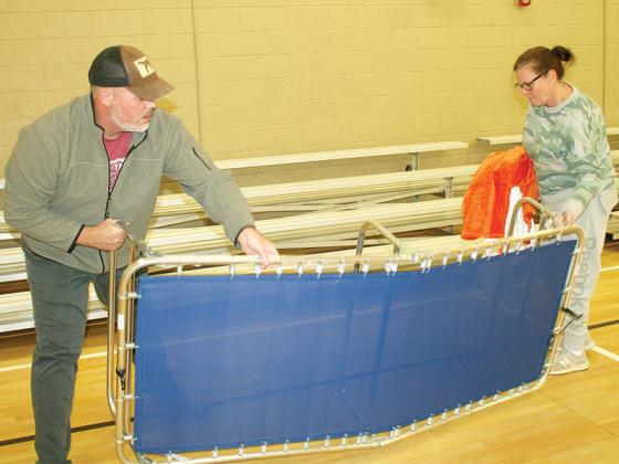 Gilmer Warming Center volunteers Joey and Laura Lyles set up cots for anyone who spends the night at the place of refuge from the cold inside the Civic Center. 