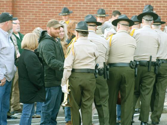 Gilmer County law enforcement officers shake hands with family of Brett Dickey, including his widow, Cindy, and brother, Joel.