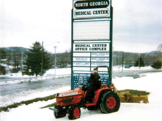 Hoyt Millholland, then-maintenance director for North Georgia Medical Center, waves from the Kubota tractor he rode from his home in Blue Ridge to work at the local hospital after the Blizzard of ’93. 
