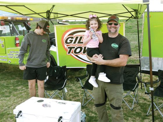 Gilmer Towing owner Darren Gaddis, right, daughter, Lakelyn and son, Christopher, offer free water to event attendees.