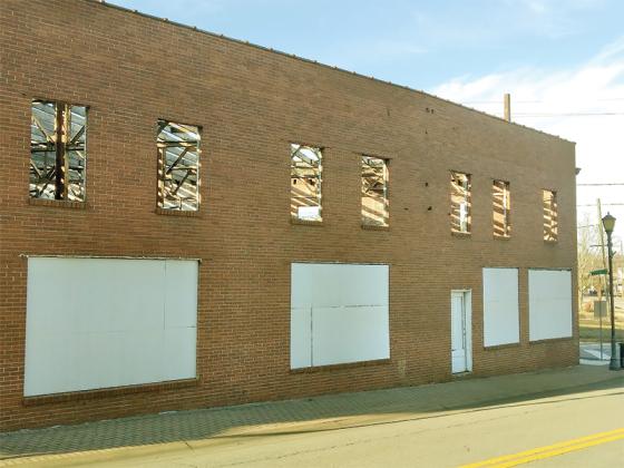 Sun shines through the rafters of the recently de-roofed Kay building, where an extensive renovation of the almost century-old former garage and car dealership continues. 