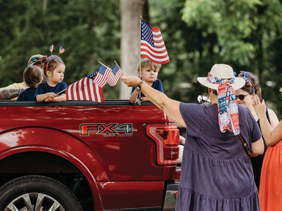 Parade participants waving their flags. (@photosbylindsayann)