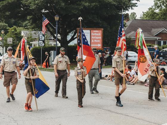 The local boy scout troop marches down River Street in the July 4th parade. (@photosbylindsayann)
