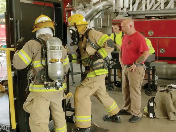 Gilmer Fire and Rescue Battalion Chief C.J. Morris, right, observes as fire department recruits Kingston Collier and Glenn Ballard use pry tools to force open a locked door during a drill that was part of last week’s training for new recruits.