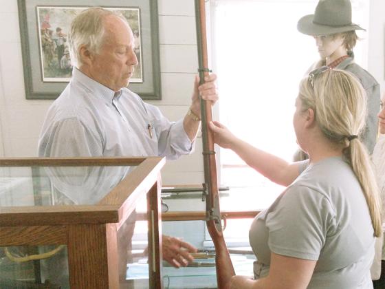 Museum volunteer Tom Cox, left, shows a replica Civil War rifle to visitor Charity Meints.
