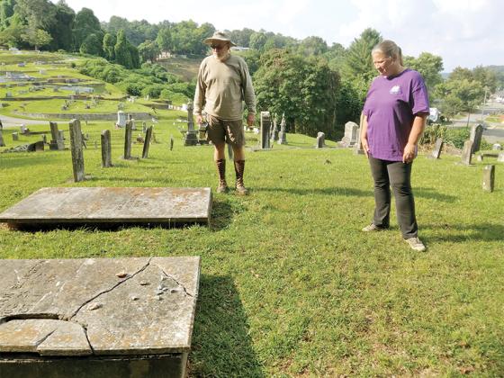 Richard Holt, left, and Beverly Ratcliff look at some of the oldest grave sites in the Ellijay City Cemetery on a workday during which the two were straightening and repairing headstones of their family members. 