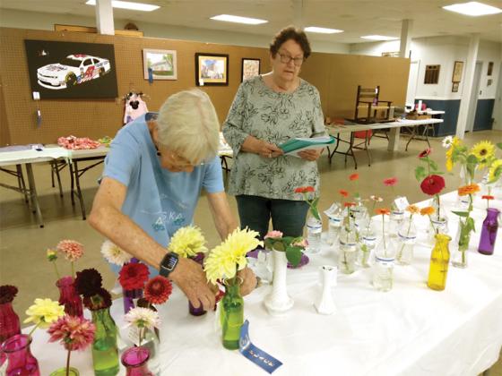 Ellijay Lions Susan Harden, left, and Ruthann Harding, right, award ribbons to the winning floral entries.